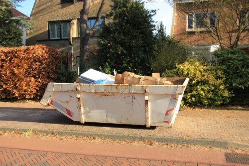Worker wearing PPE during a skip loading operation